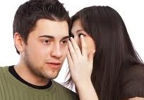 woman wispering in a man's ear